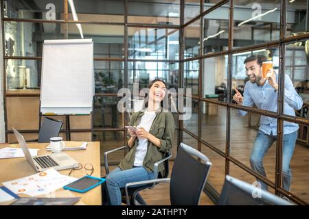 Two smiling office workers having fun during coffee break Stock Photo