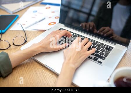 Close up picture of womans hands typing on laptop Stock Photo