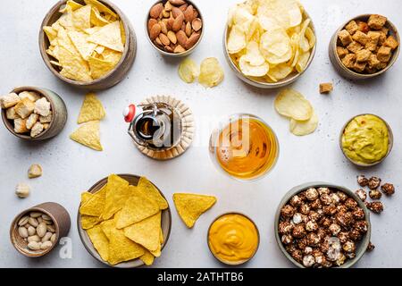 Veraity bowls of beer snacks and sauces on stone table. Nuts, chips, nachos, crackers. Top view with copyspace Stock Photo