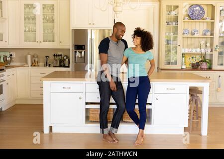 Happy young couple standing in the kitchen Stock Photo