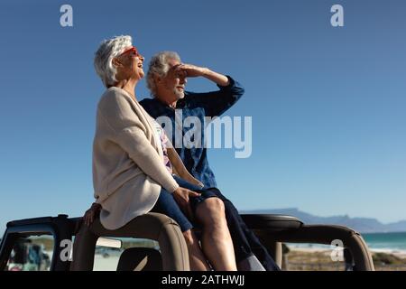 Old couple with a car at the beach Stock Photo