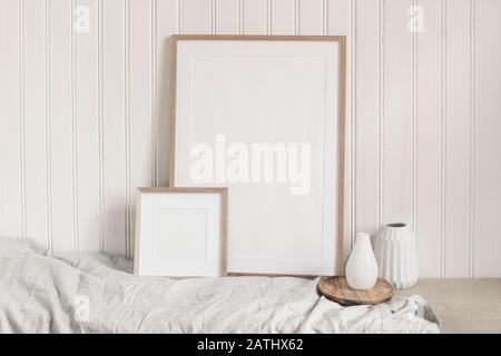 Portrait and square empty wooden frame mockups with linen cloth and modern ceramic vases. White beadboard wainscot wall paneling background. Scandinav Stock Photo