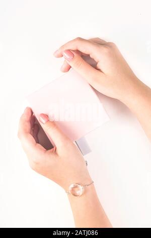 Delicate pink box with a gift in female hands on a white background. Holiday, March 8, Valentine's Day concept. Mock up Stock Photo