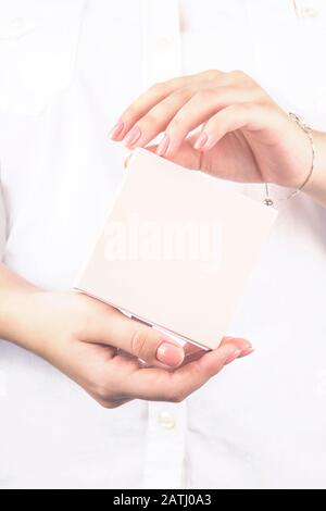 Delicate pink box with a gift in female hands on a white background. Holiday, March 8, Valentine's Day concept. Mock up Stock Photo