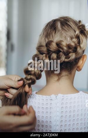 Mother do hair braid to her daughter, close up photo Stock Photo