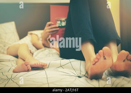 mother reading fairy book to her child in the evening before sleep at home Stock Photo