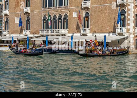 Tourists taking a gondola ride passing The Hotel Gritti Palace a luxury hotel on The Grand Canal ,Venice ,Italy Stock Photo