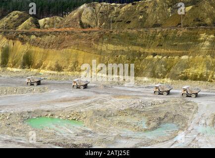 Big yellow mining trucks working in the limestone open-pit. Loading and transportation of minerals in the chalk open-pit. Belarus, Krasnoselsk, in the Stock Photo