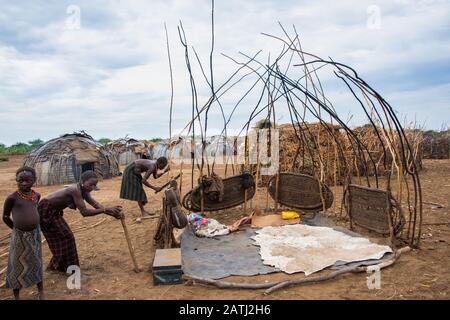 Omorate, Ethiopia - Nov 2018: Dasanech tribe women constructing a house in  the village. Omo valley Stock Photo