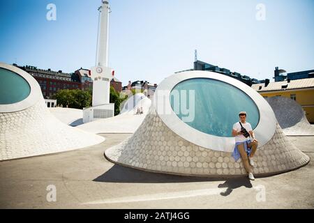 New art museum Amos Rex in the center of Helsinki. Modern northern architecture. people relaxing on futuristic slopes, enjoying sunshine on the square Stock Photo