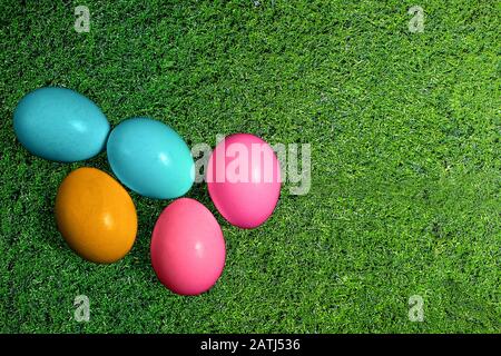 Easter eggs on green grass background. Multicolor Easter symbol eggs flat lay top view with copy space. Seasonal spring holiday decoration Stock Photo