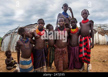 Omorate, Ethiopia - Nov 2018: Dasanech tribe women and kids standing proudly wearing traditional clothes and necklaces Stock Photo