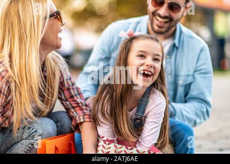 Family having fun outdoor after shopping.Family with daughter doing shopping in the city. Stock Photo