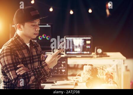 Editor man checking email on mobile and connecting online or watching the video clip Stock Photo