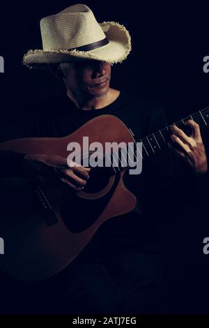 Guitar classic a man enjoying music on black isolated background Stock Photo
