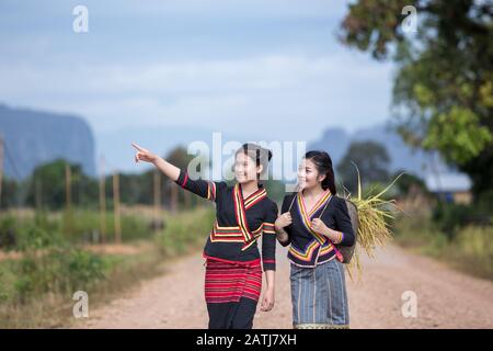 Laos Two women walking  watching nature and rice field of them in Kong Lor Village Laos Stock Photo