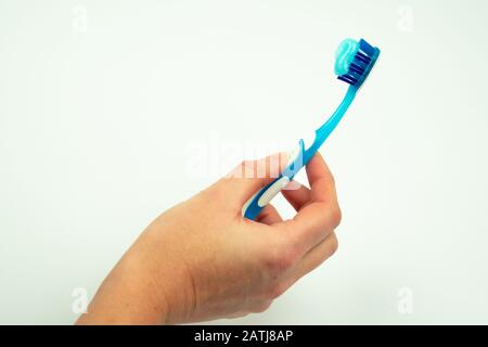 Female hand holding toothbrush with toothpaste isolated on white ...