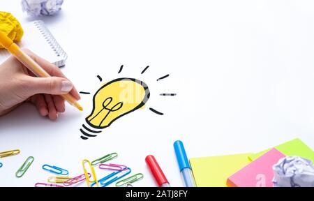 Creative new idea. Innovation, brainstorming, inspiration and solution concepts. Designer drawing a light bulb. Stock Photo