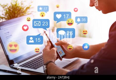 Like and share social media. Hands holding smartphone with social media network icons. Marketing concept. Stock Photo