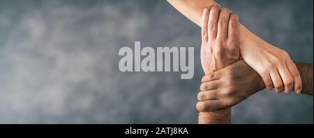 Top view of young people holding hands. Symbol and concept of unity, teamwork and support. Stock Photo