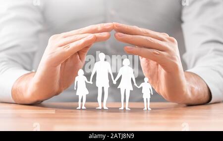 Hands with cut out paper silhouette on table. Family care concept. Stock Photo