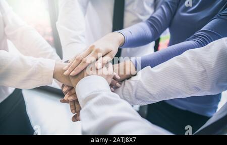 Close up view of young business people putting their hands together. Stack of hands. Unity and teamwork concept. Stock Photo