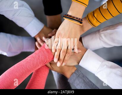 Close up top view of young business people putting their hands together. Stack of hands. Unity and teamwork concept. Stock Photo