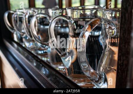 glass water jugs in a row on the restaurant's bar Stock Photo