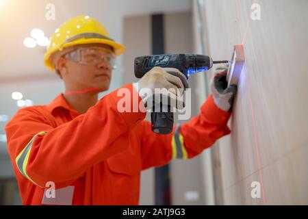 Technicians are working to penetrate the wall with a power drill. Stock Photo