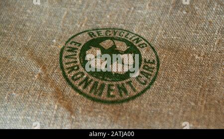 Recycling stamp printed on linen sack. Recycle symbol, arrows, recyclable materials, environmental protection and earth safe concept. Stock Photo