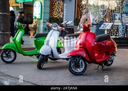 Three white, red, green color Scooter parked on old street in Odessa Stock Photo