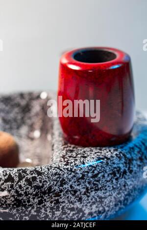 Macro picture ashtray with red pipe Stock Photo