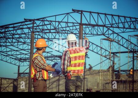 Engineering working in the construction and using the blueprint for checking construction Stock Photo