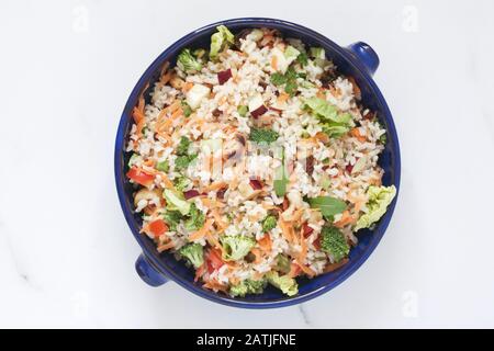 Brown rice salad in a bowl on a  marble surface. Stock Photo