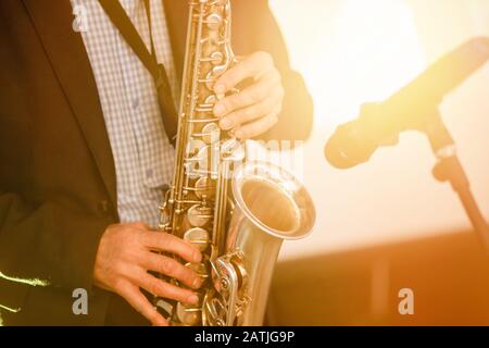 Jazz man musician playing saxophone with sun light Stock Photo