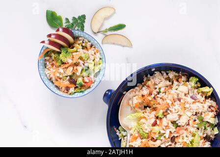 Brown rice salad in a bowl on a  marble surface. Stock Photo