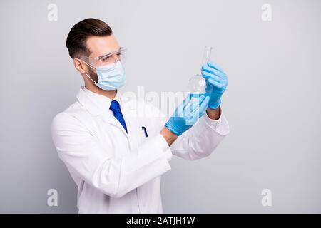 Close-up profile side portrait of his he nice attractive focused skilled experienced doc scientist making analysis lab center holding bulb in hands Stock Photo