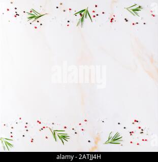 Food background, spices and seasonings, rosemary with salt and pepper on white cream marble table, copy space, flat lay, top view Stock Photo