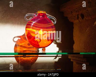 A glass vase creates amazing shadows and reflections as it is illuminated by the afternoon sun. Stock Photo