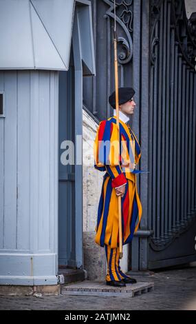 A Pontifical Swiss Guard stands outside an entrance to St. Peters Basilica, Vatican City, Rome, Italy. Stock Photo