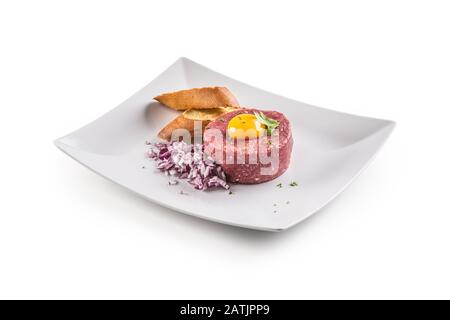 Beef tartare with egg yolk red onion herbs and bruschetta isolated on white Stock Photo