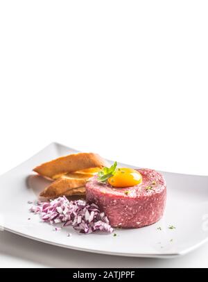Beef tartare with egg yolk red onion herbs and bruschetta isolated on white Stock Photo