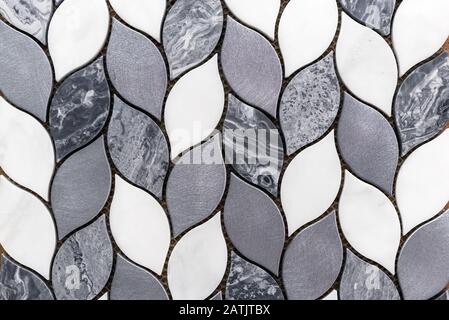 Marble gray and white tile mosaic in the form of a pigtail. Stock Photo