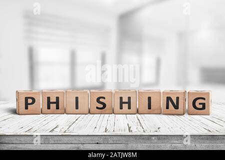 Phishing scam sign on a wooden table in a bright office with blocks Stock Photo