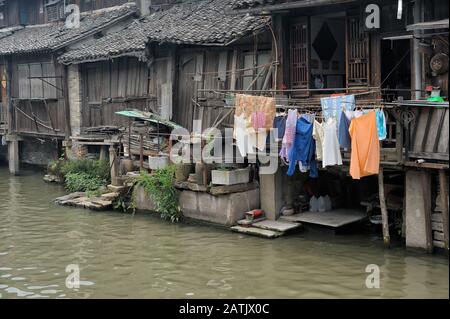 Poor residential area with dilapidated houses with clothes drying outdoor in Chinese water village. Stock Photo