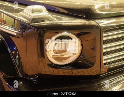 Close-up photo of headlights on black shiny car Stock Photo