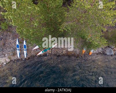 Rafting kayaks on bank of mountain river with rocky shore. Aerial top view Stock Photo