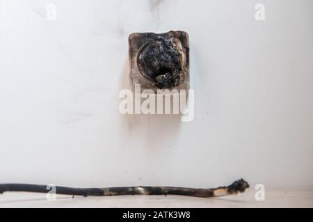 Electrical short circuit Effects. Failure caused by burning wire and rosettes socket plug in house Stock Photo