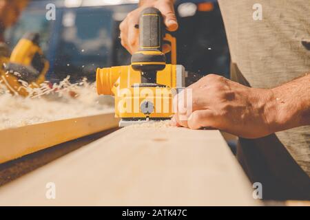 Electric planer for processing wooden paintings, workshop furniture, professional using craft equipment Stock Photo
