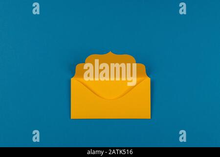 Communication, newsletter and business concept- yellow colorful envelope on blue background, selective focus. Stock Photo